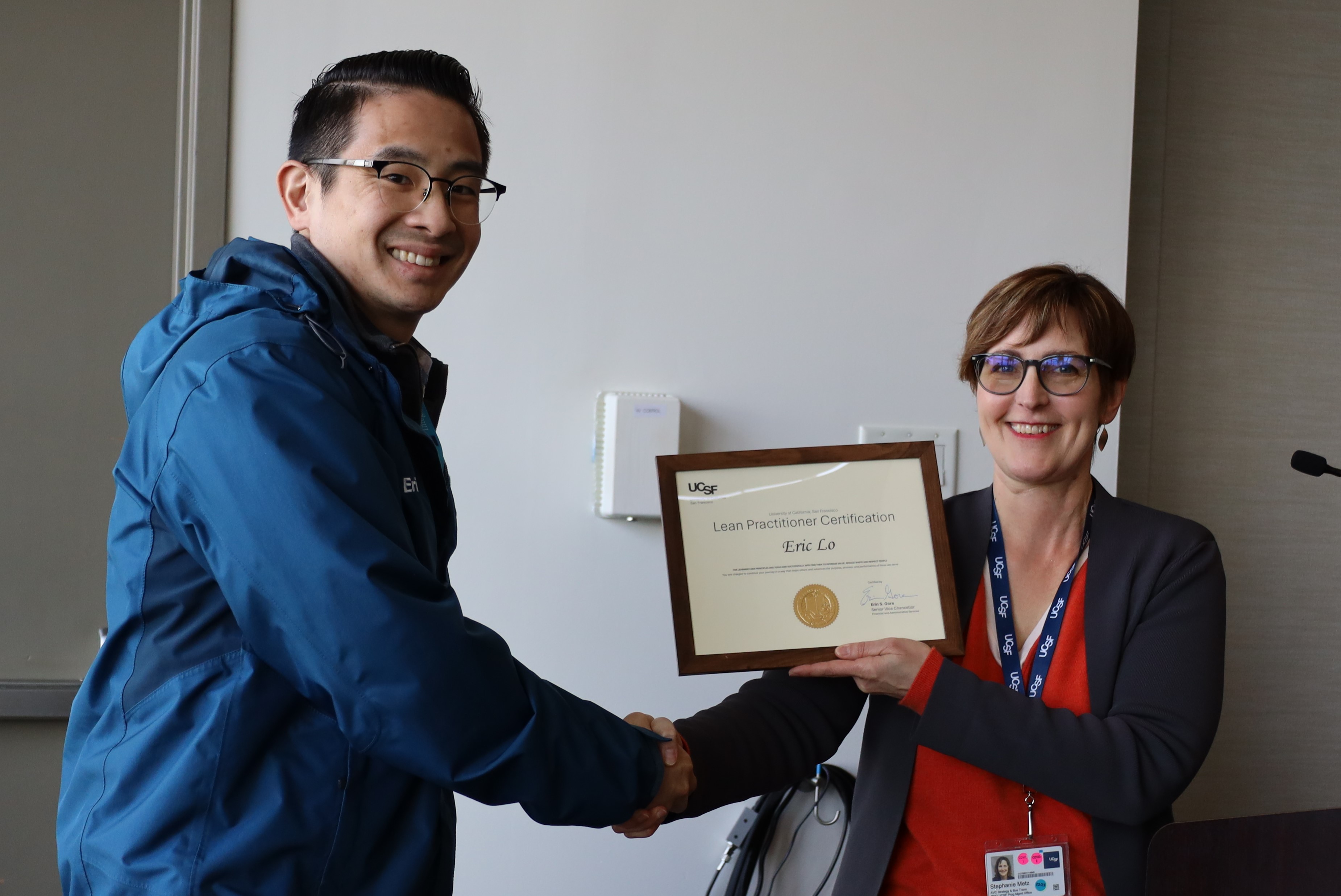 Eric Lo receiving his Lean Practitioner Certificate from Stephanie Metz for his project "Service Level Agreements"